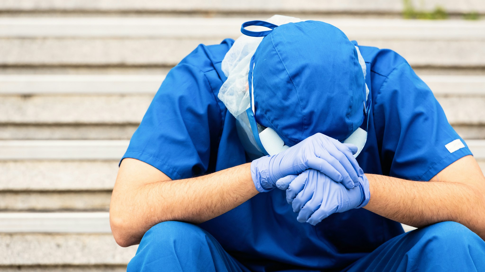 Serious, overworked, very sad male health care worker - stock photo