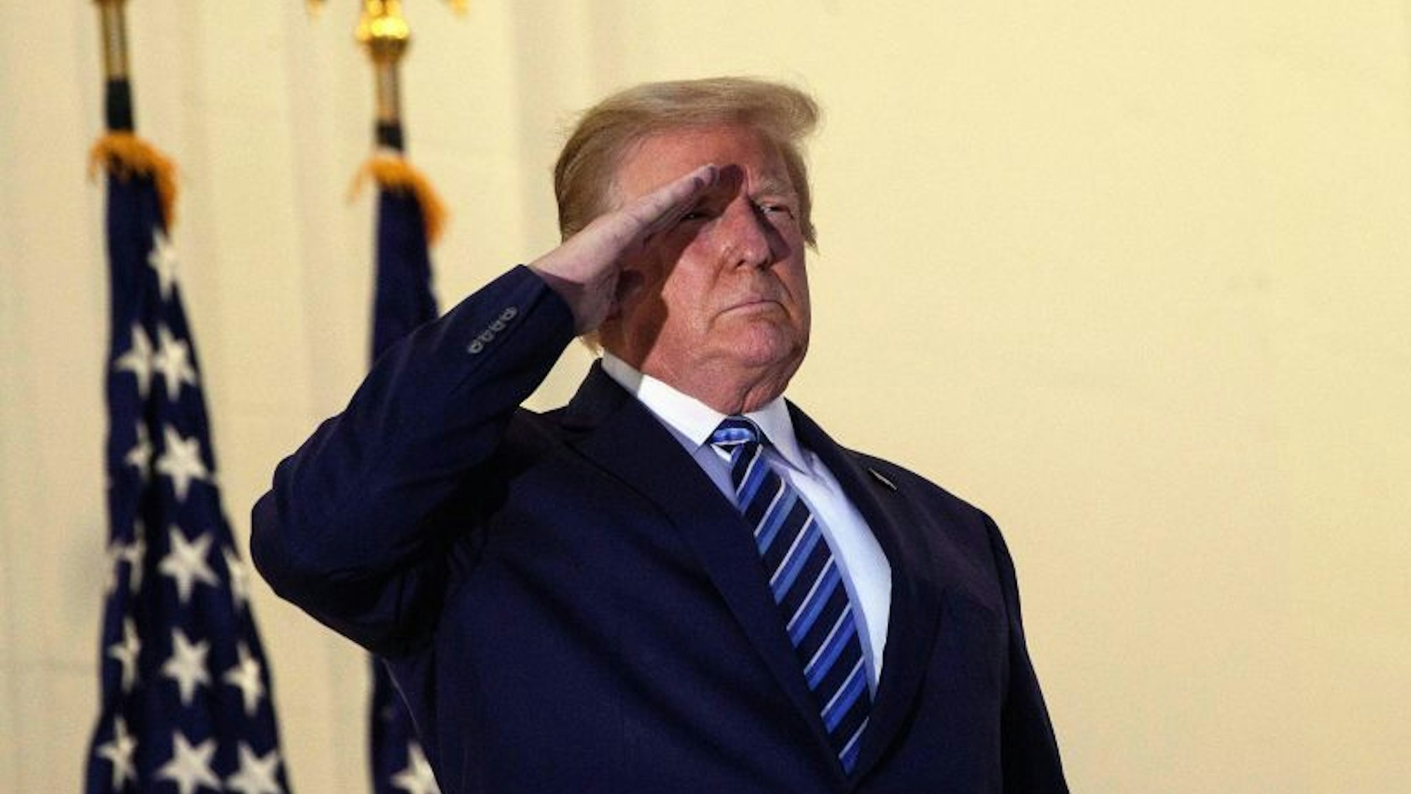 US President Donald Trump salutes from the Truman Balcony upon his return to the White House from Walter Reed Medical Center, where he underwent treatment for Covid-19, in Washington, DC, on October 5, 2020.