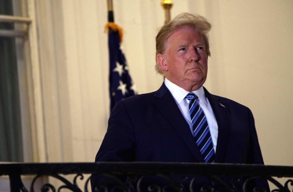 US President Donald Trump looks out from the Truman Balcony upon his return to the White House from Walter Reed Medical Center, where he underwent treatment for Covid-19, in Washington, DC, on October 5, 2020.