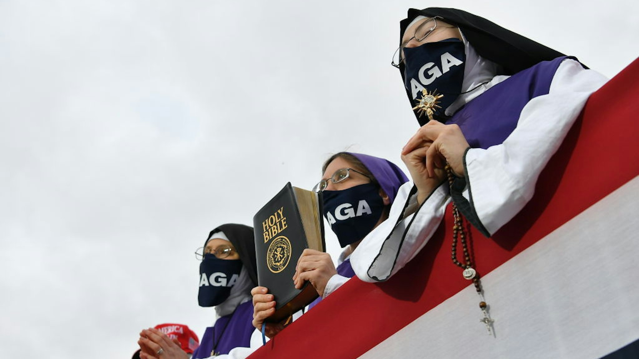 Nuns wearing masks displaying Trump's MAGA slogan listen as US President Donald Trump speaks during a campaign rally at Pickaway Agriculture and Event Center in Circleville, Ohio on October 24, 2020.