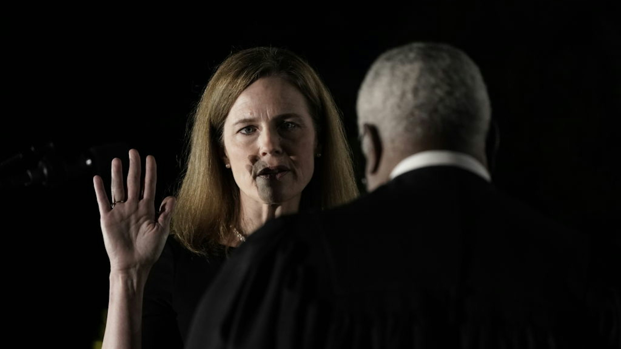 Clarence Thomas, associate justice of the U.S. Supreme Court, right, administers the judicial oath to Amy Coney Barrett, associate justice of the U.S. Supreme Court, during a ceremony on the South Lawn of the White House in Washington, D.C.,