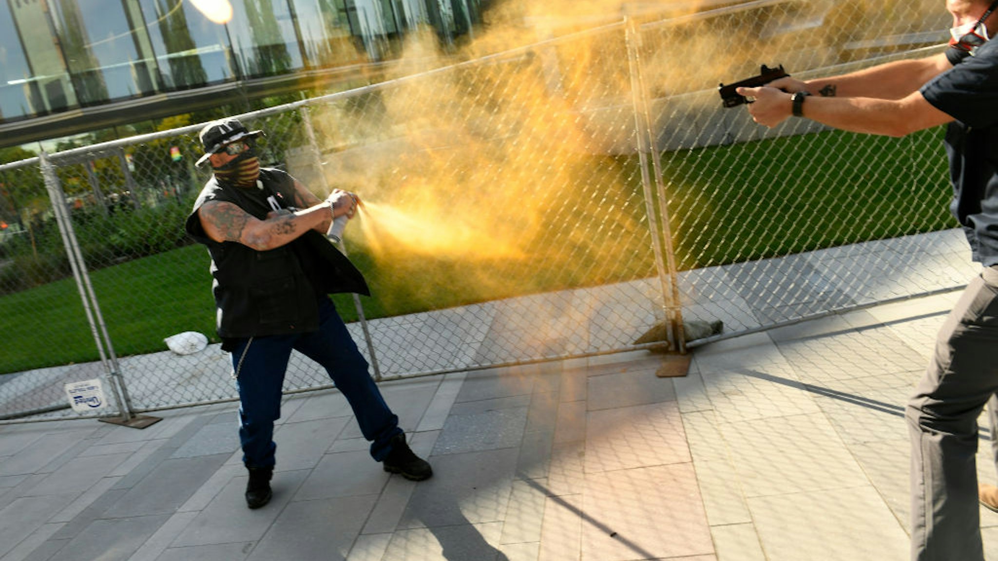 DENVER, COLORADO - OCTOBER 10: Two men clash after dueling rallies in Downtown Denver on October 10, 2020 in Denver, Colorado. The man on the left side of the photo sprays what appears to be pepper spray at the man on the right side of the image. The man at right, fires his gun at the protester at left. The shooting happened as opposing rallies by far-right and far-left activists were ending. The shooter has been identified as Matthew Dolloff. He is being held for investigation of First Degree Murder in connection with this shooting. (Photo by Helen H. Richardson/MediaNews Group/The Denver Post via Getty Images)