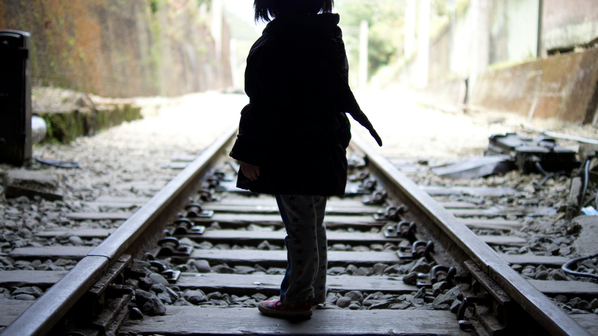 Little girl walking on the railroad track of Shengxing Railway Station, Miaoli Taiwan. - stock photo