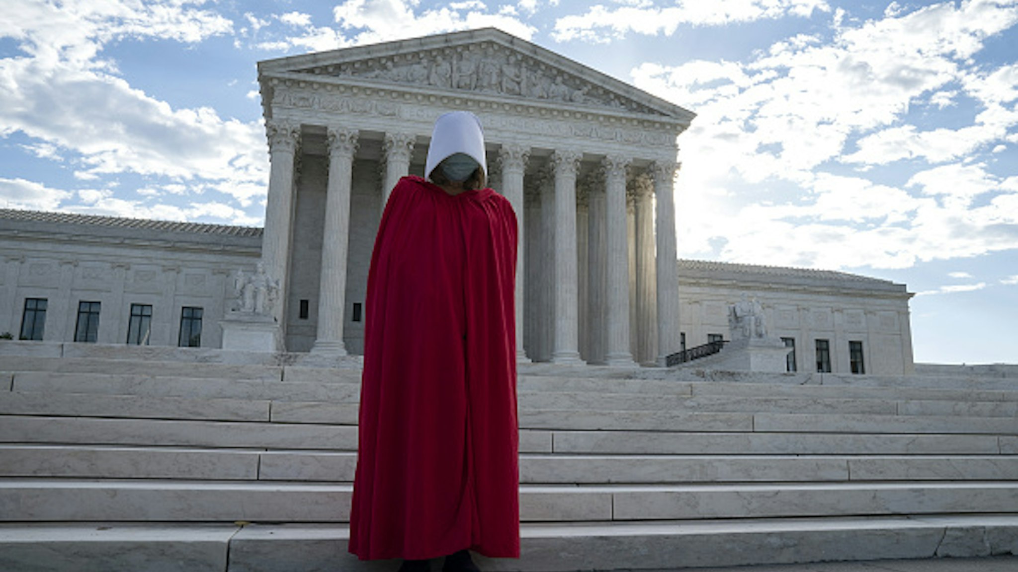 A demonstrator dressed as a character from The Handmaid's Tale stands outside the U.S. Supreme Court as Amy Coney Barrett, U.S. President Donald Trump's nominee for associate justice of the U.S. Supreme Court, meets with Senators at the U.S. Capitol in Washington, D.C., U.S., on Thursday, Oct. 1, 2020. A bruising Senate confirmation fight over Trump's Supreme Court choice may seal the fates of several incumbent senators in the November election, though it has yet to drastically alter the odds for which party will control the chamber.