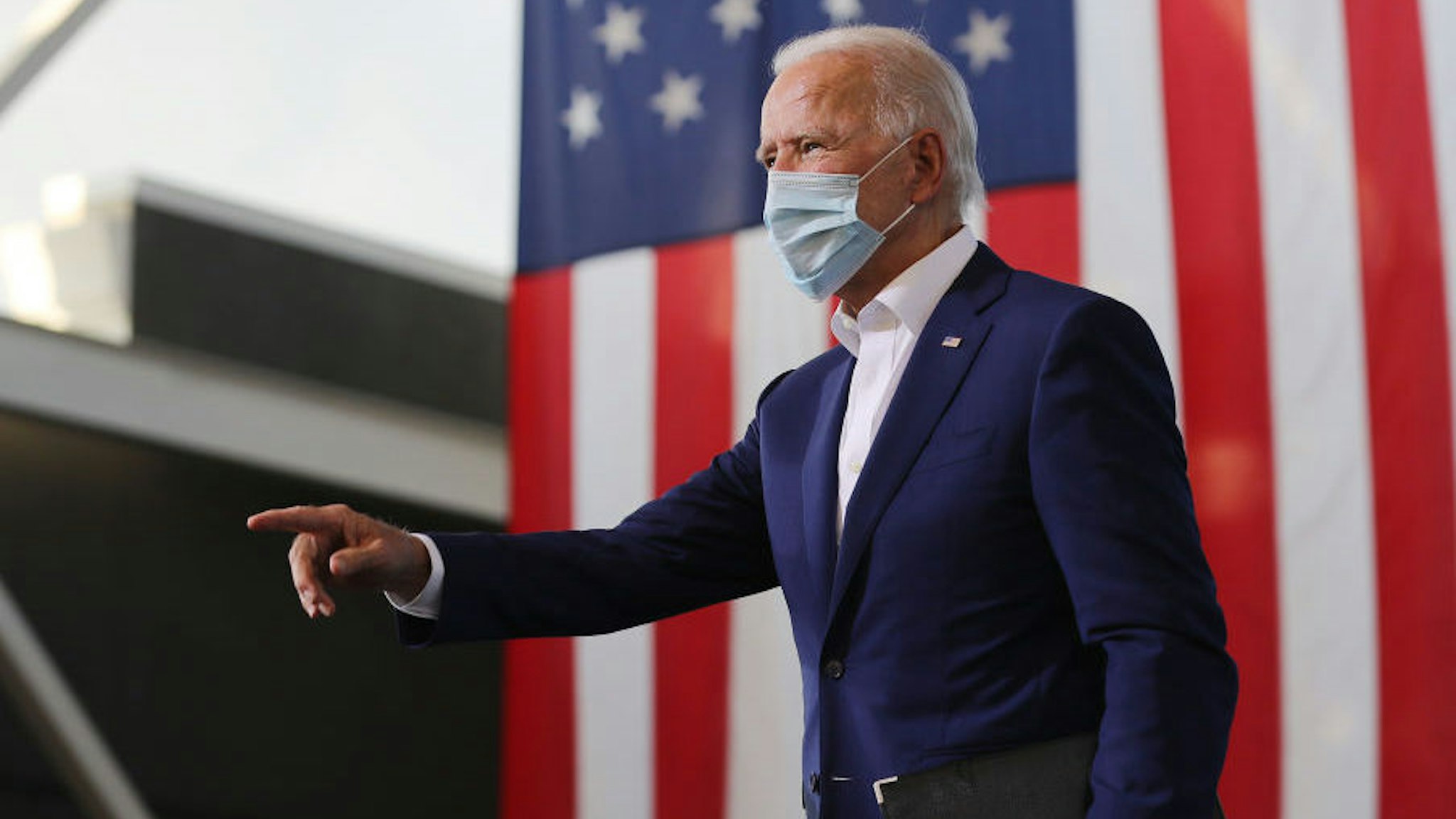 Wearing a face mask to reduce the risk posed by the coronavirus, Democratic presidential nominee Joe Biden points to supporters during a drive-in voter mobilization event at Miramar Regional Park October 13, 2020 in Miramar, Florida. With three weeks until Election Day, Biden is campaigning in Florida. (Photo by Chip Somodevilla/Getty Images)