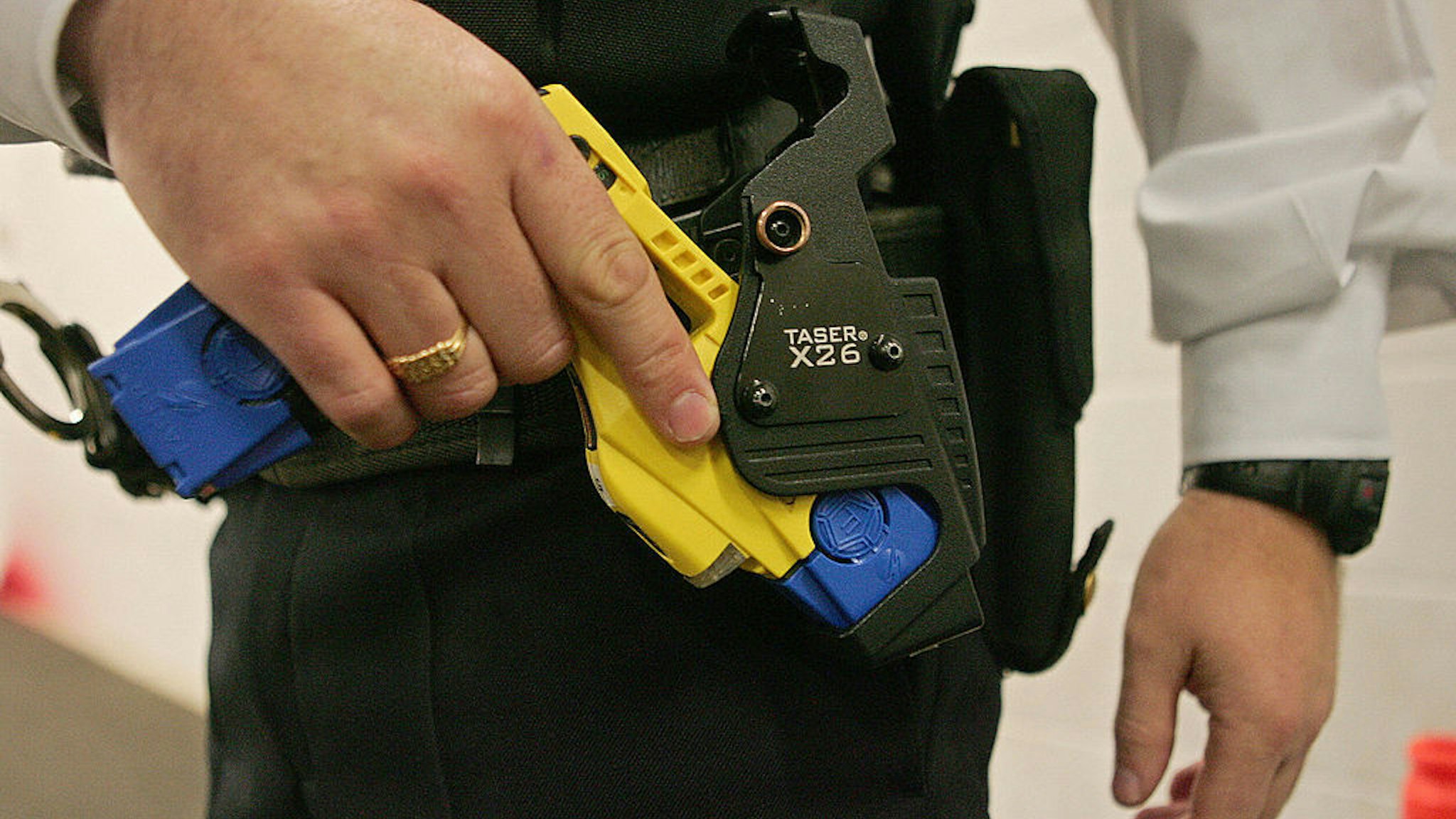 A British police officer holsters a taser gun during a training session at the Metropolitan Police Specialist Training Centre, in Gravesend, Kent, in south-east England, 05 December 2007. Taser guns are to be issued to London's Metropolitan Police from Monday 10 December 2007. AFP PHOTO/CARL DE SOUZA/FILES