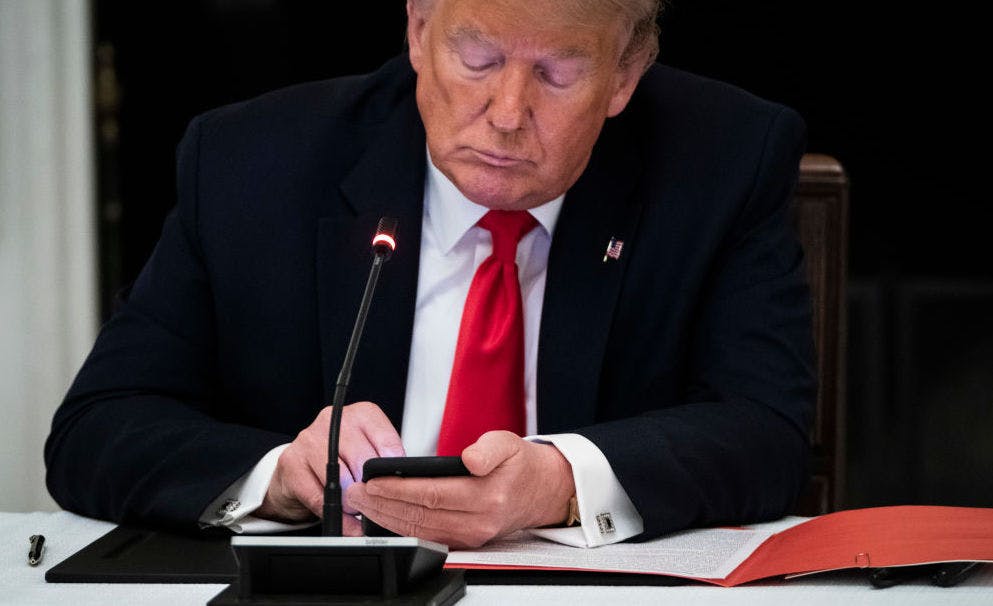 WASHINGTON, DC - JUNE 18: President Donald J. Trump uses his cellphone as he participates in a roundtable discussion with Governors and small business owners on the reopening of Americas small businesses in the State Dinning Room at the White House on Thursday, June 18, 2020 in Washington, DC.