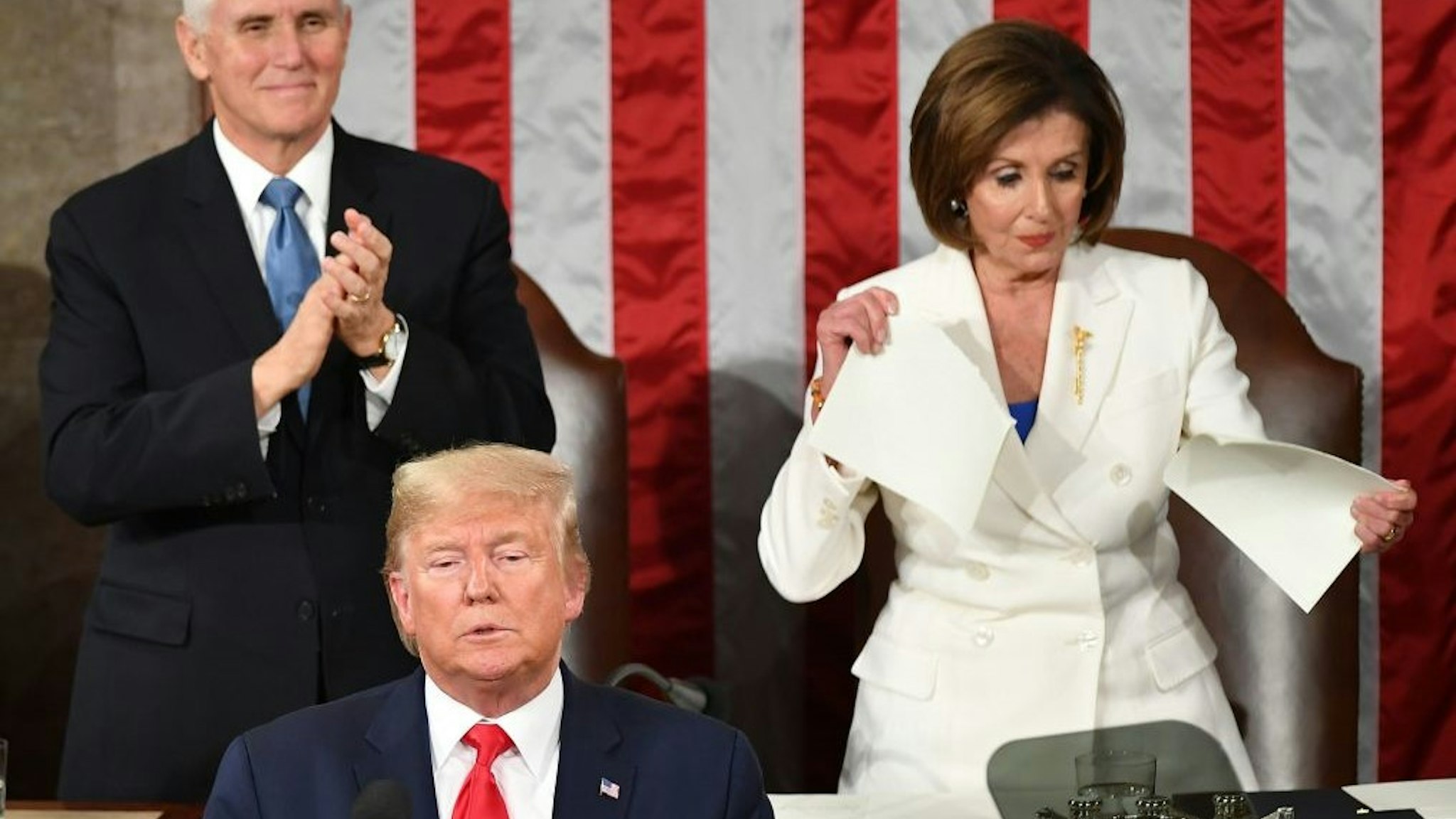 TOPSHOT - US Vice President Mike Pence claps as Speaker of the US House of Representatives Nancy Pelosi appears to rip a copy of US President Donald Trumps speech after he delivers the State of the Union address at the US Capitol in Washington, DC, on February 4, 2020. (Photo by MANDEL NGAN / AFP) (Photo by