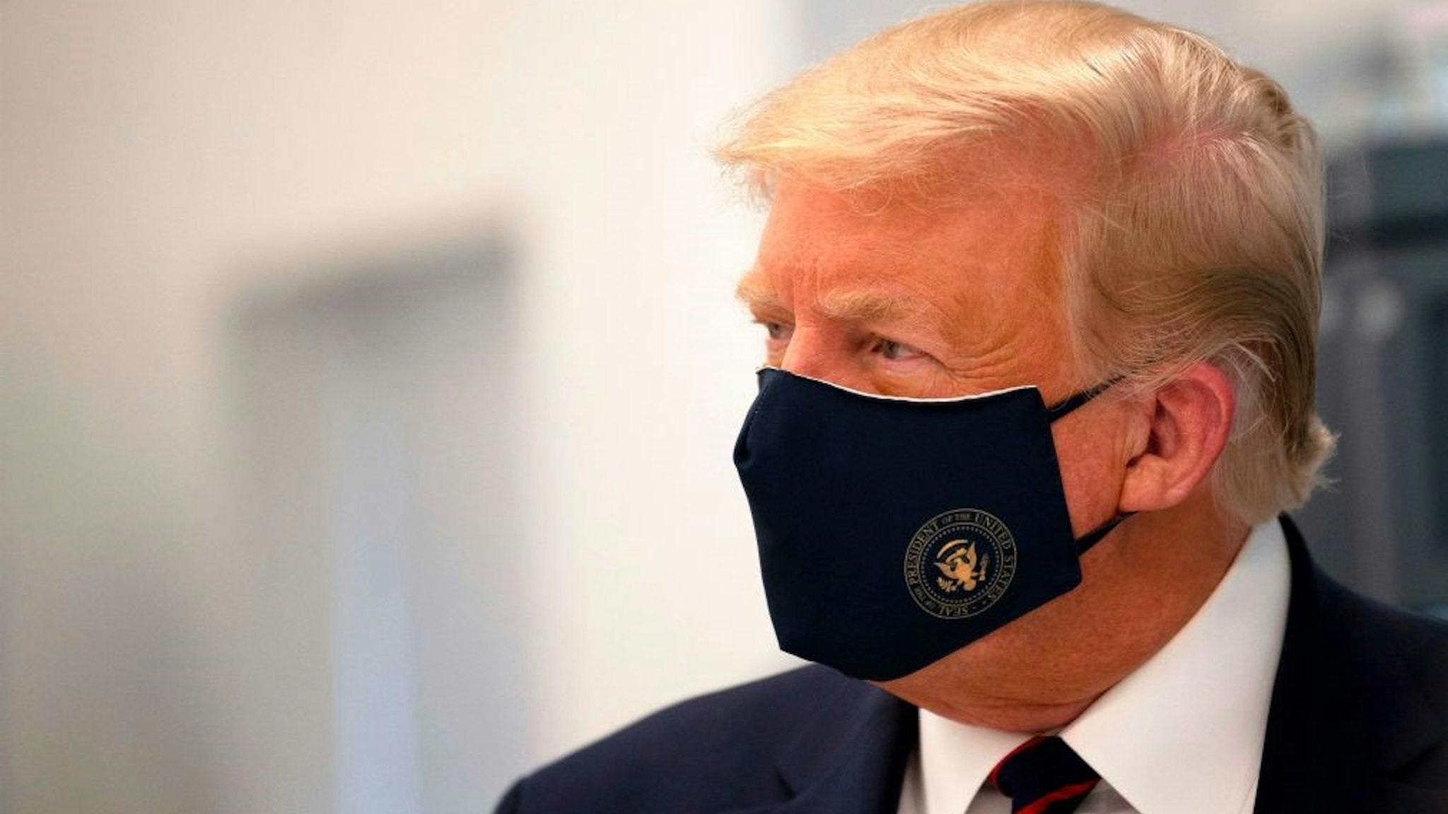 TOPSHOT - US President Donald Trump wears a mask as he tours a lab where they are making components for a potential vaccine at the Bioprocess Innovation Center at Fujifilm Diosynth Biotechnologies in Morrisville, North Carolina on July 27, 2020. (Photo by JIM WATSON / AFP) (Photo by