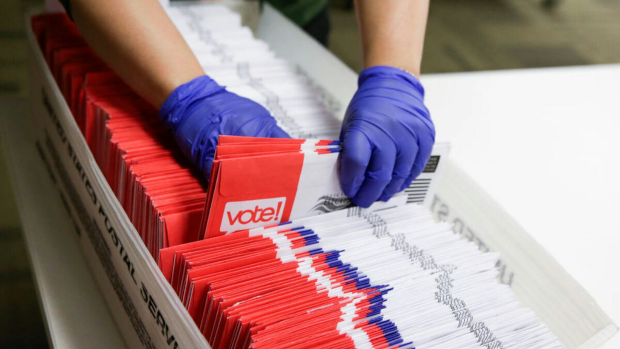 Election workers sort vote-by-mail ballots for the presidential primary at King County Elections in Renton, Washington on March 10, 2020.