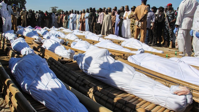 TOPSHOT - Mourners attend the funeral of 43 farm workers in Zabarmari, about 20km from Maiduguri, Nigeria, on November 29, 2020 after they were killed by Boko Haram fighters in rice fields near the village of Koshobe on November 28, 2020. - The assailants tied up the agricultural workers and slit their throats in the village of Koshobe. The victims were labourers from Sokoto state in northwest Nigeria, roughly 1,000 kilometres (600 miles) away, who had travelled to the northeast to find work.