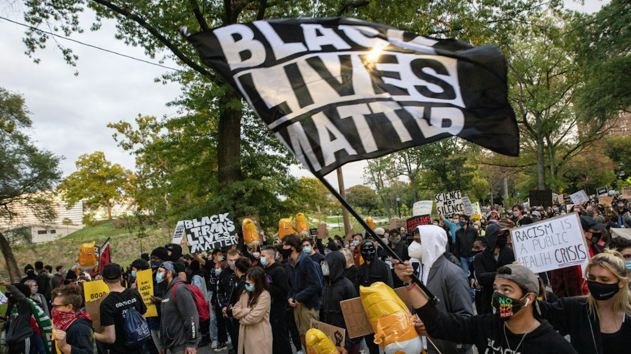 CLEVELAND, OHIO, UNITED STATES - 2020/09/29: Protesters wearing masks march through University Circle while holding up placards and banners during the protest.