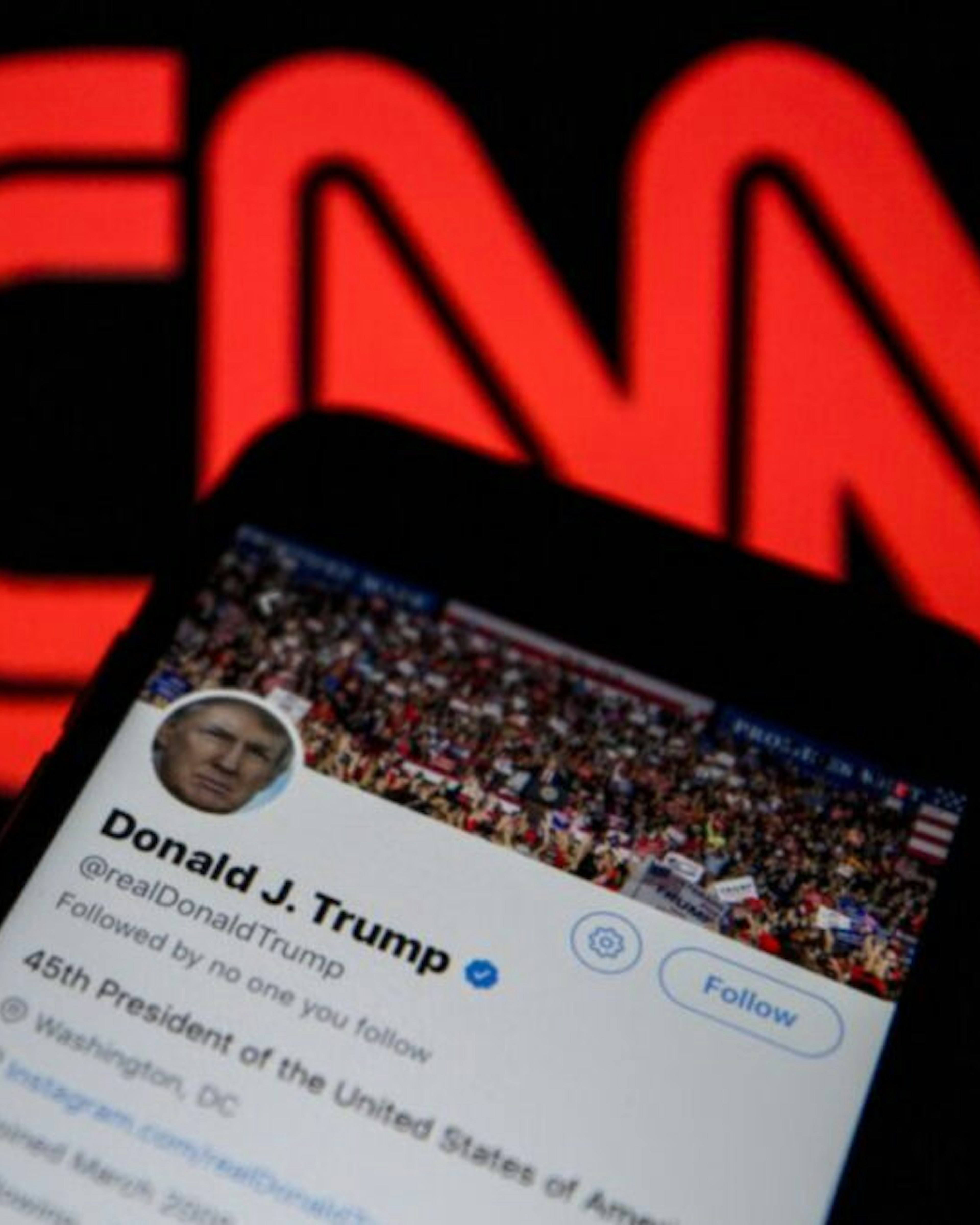 Donald Trump's Twitter timeline is seen on a smartphone against a backdrop with the CNN TV channel logo, in Ankara, Turkey on December 9, 2018.