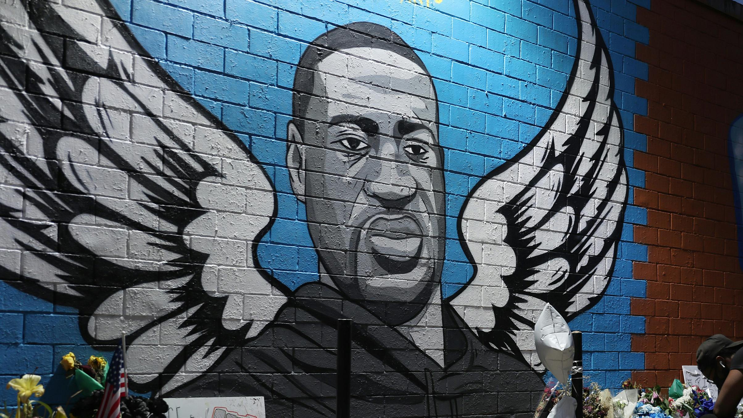 HOUSTON, TEXAS - JUNE 08: Joshua Broussard kneels in front of a memorial and mural that honors George Floyd at the Scott Food Mart corner store in Houston's Third Ward where Mr. Floyd grew up on June 8, 2020 in Houston, Texas. The funeral and burial for George Floyd will be held June 9. Floyd died on May 25th while in Minneapolis police custody, sparking nationwide protests.