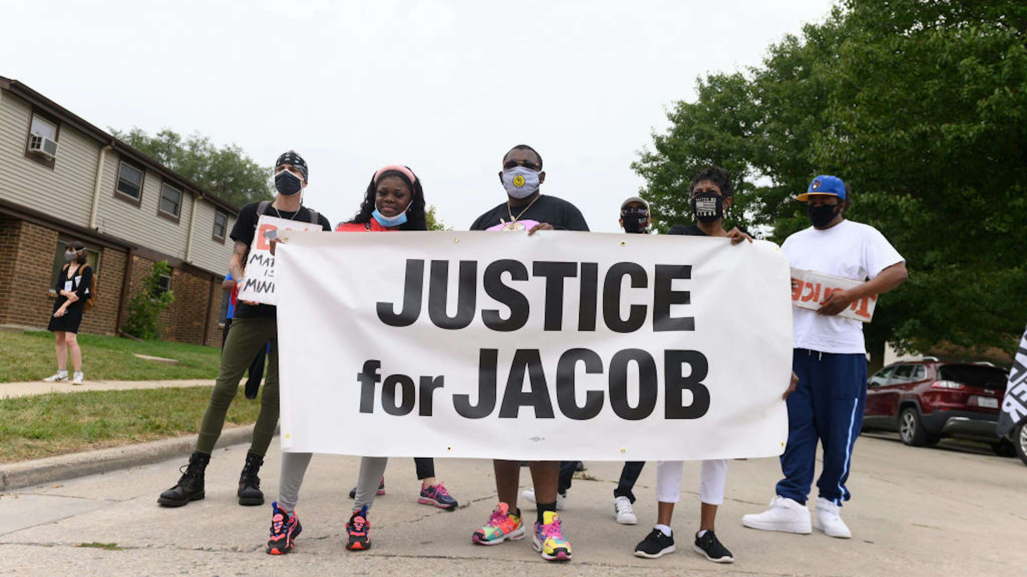 Protesters hold a banner during a community celebration and call for justice for Jacob Blake as grassroots group MoveOn flies an airplane banner and drives a mobile billboard calling on voters to "Reject Trump's Violence," in response to Donald Trump's visit on September 01, 2020 in Kenosha, Wisconsin.
