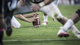 Football American football players readying to kick ball. - stock photo