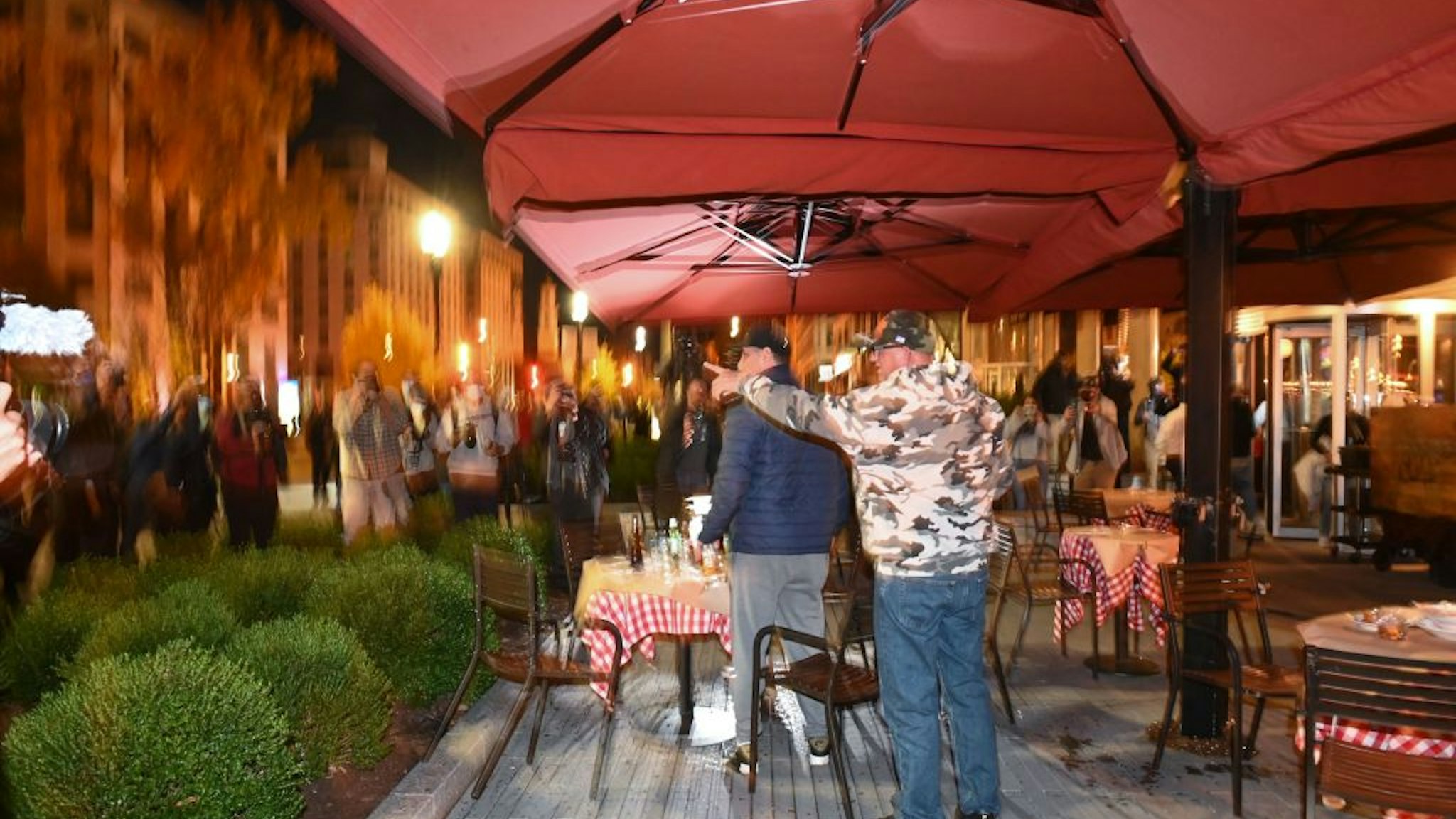 Trump supporters react as a crowd closes in on them at the terrace of a restaurant near Black Lives Matter Plaza in Washington, DC on November 14, 2020.