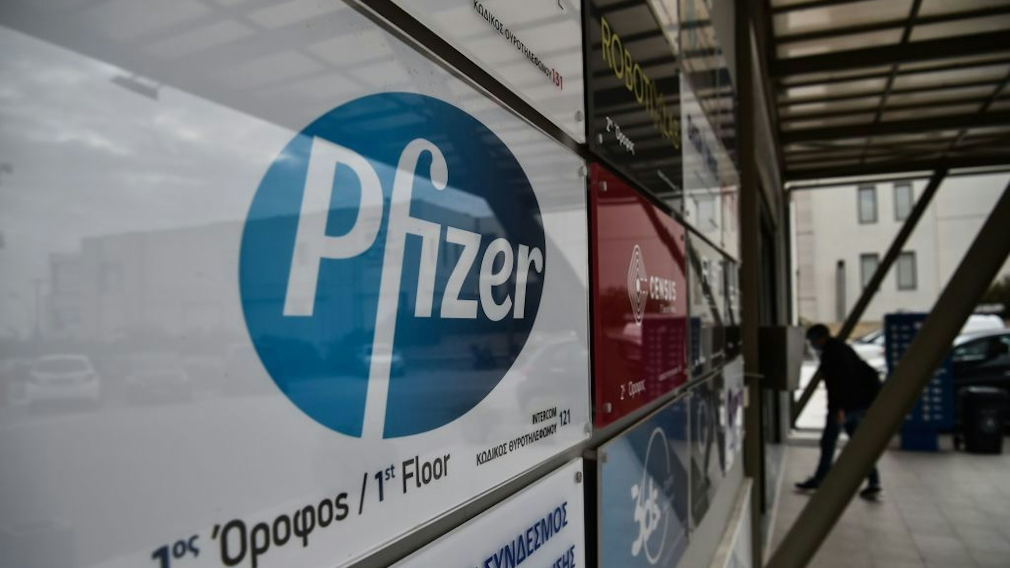 A man entry at the building where Pfizer's office located in Thessaloniki on November 10, 2020. - Pfizer stock surged higher on November 9, 2020 prior to the opening of Wall Street trading after the company announced its vaccine is "90 percent effective" against Covid-19 infections. The news cheered markets worldwide, especially as coronavirus cases are spiking, forcing millions of people back into lockdown. (Photo by Sakis MITROLIDIS / AFP) (Photo by SAKIS MITROLIDIS/AFP via Getty Images)