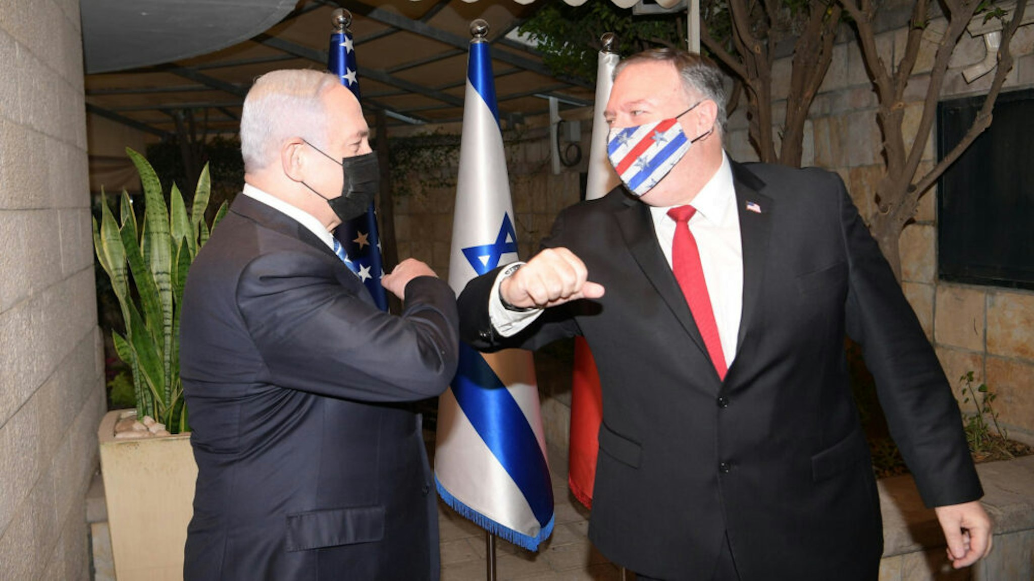 JERUSALEM - NOVEMBER 18: (----EDITORIAL USE ONLY MANDATORY CREDIT - "ISRAELI PRIME MINISTRY / HANDOUT" - NO MARKETING NO ADVERTISING CAMPAIGNS - DISTRIBUTED AS A SERVICE TO CLIENTS----) Israeli Prime Minister Benjamin Netanyahu (L) and US Secretary of State Mike Pompeo (R) greet each other with an elbow bump ahead of their meeting at the Prime Ministry Office in West Jerusalem on November 18, 2020. Bahraini Minister for Foreign Affairs Abdullatif bin Rashid Al Zayani (not seen) also attended the meeting.