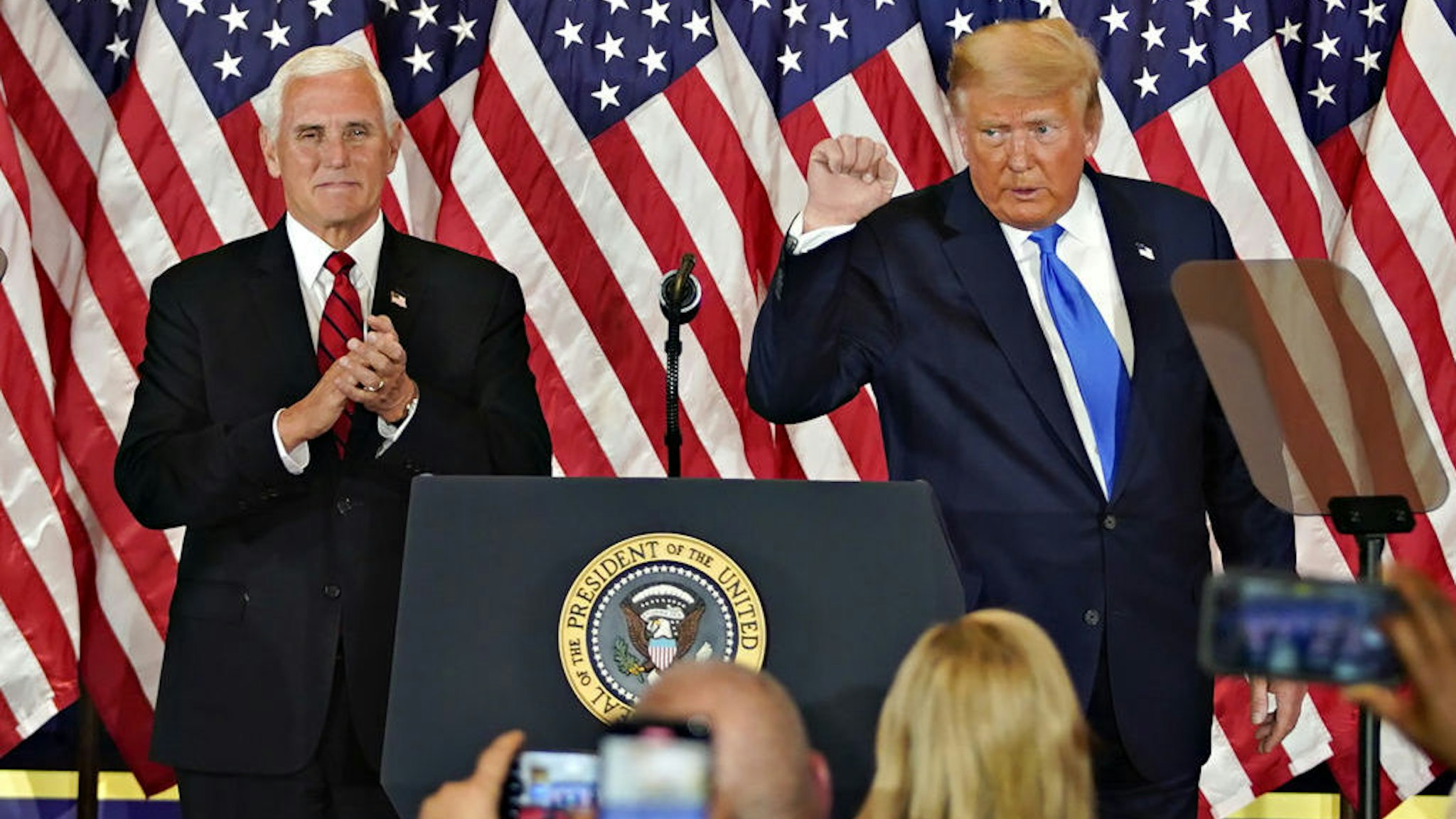 U.S. President Donald Trump gestures after speaking during an election night party with U.S. Vice President Mike Pence, left, in the East Room of the White House in Washington, D.C., U.S., on Wednesday, Nov. 4, 2020. Trump declared he had won re-election against Joe Biden and said he would ask the Supreme Court to intervene, even as several battleground states continue to count votes. Photographer: Al Drago/Bloomberg