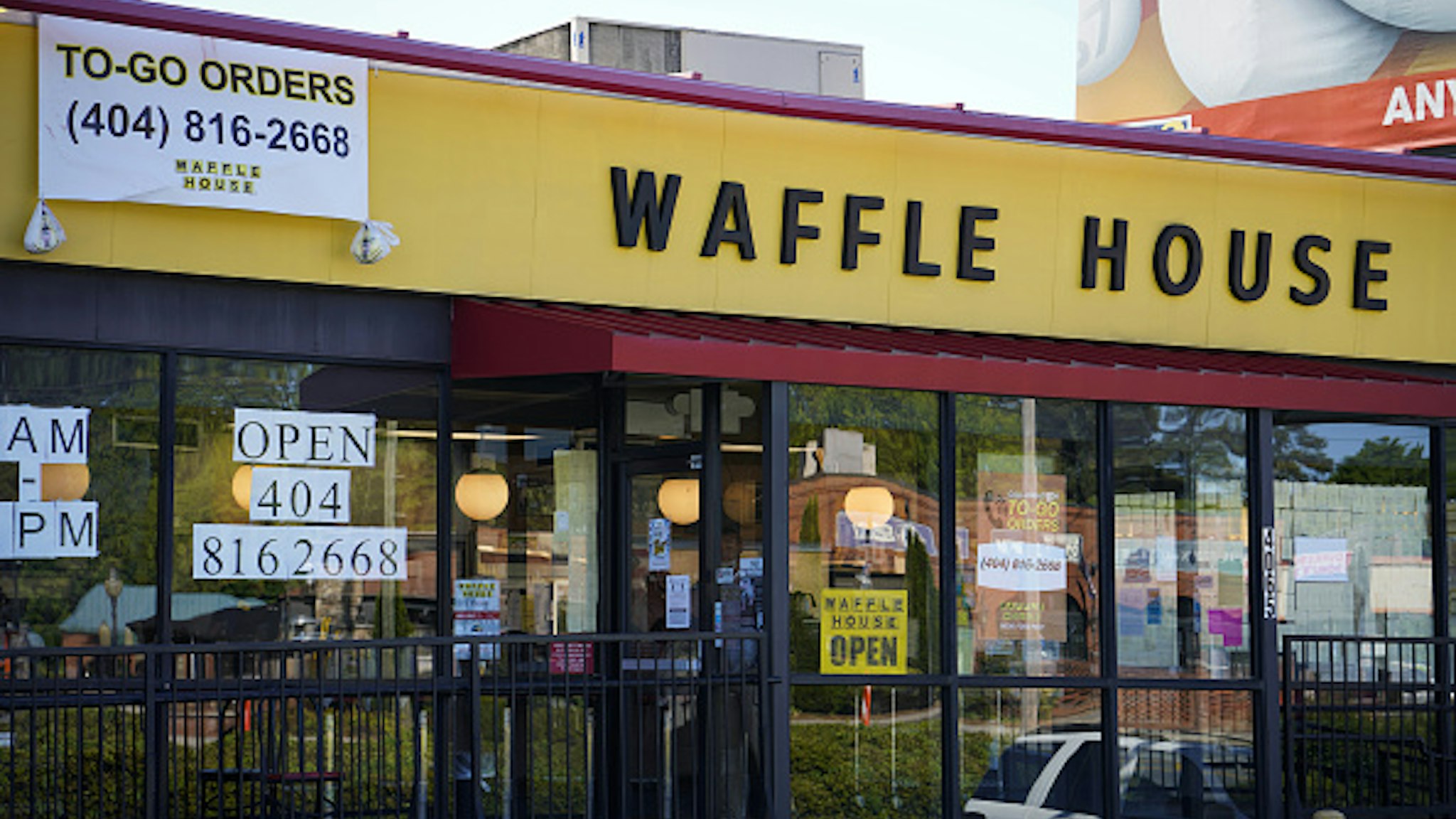 An "Open" sign hangs in the window of a Waffle House Inc. restaurant in Brookhaven, Georgia, U.S., on Monday, April 27, 2020. After closing more than 400 locations across the U.S. last month due to the coronavirus outbreak, the chain thats barely flinched during hurricane season is preparing for its biggest test yet.