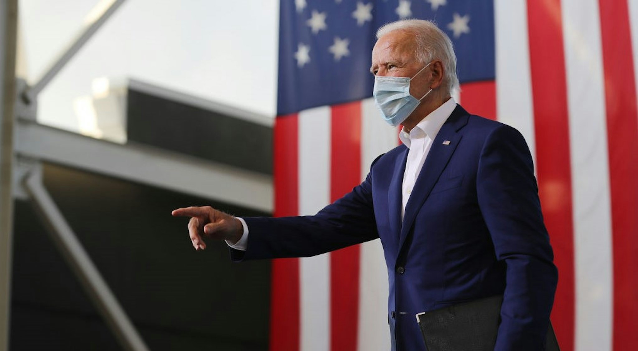 MIRAMAR, FLORIDA - OCTOBER 13: Wearing a face mask to reduce the risk posed by the coronavirus, Democratic presidential nominee Joe Biden points to supporters during a drive-in voter mobilization event at Miramar Regional Park October 13, 2020 in Miramar, Florida. With three weeks until Election Day, Biden is campaigning in Florida. (Photo by
