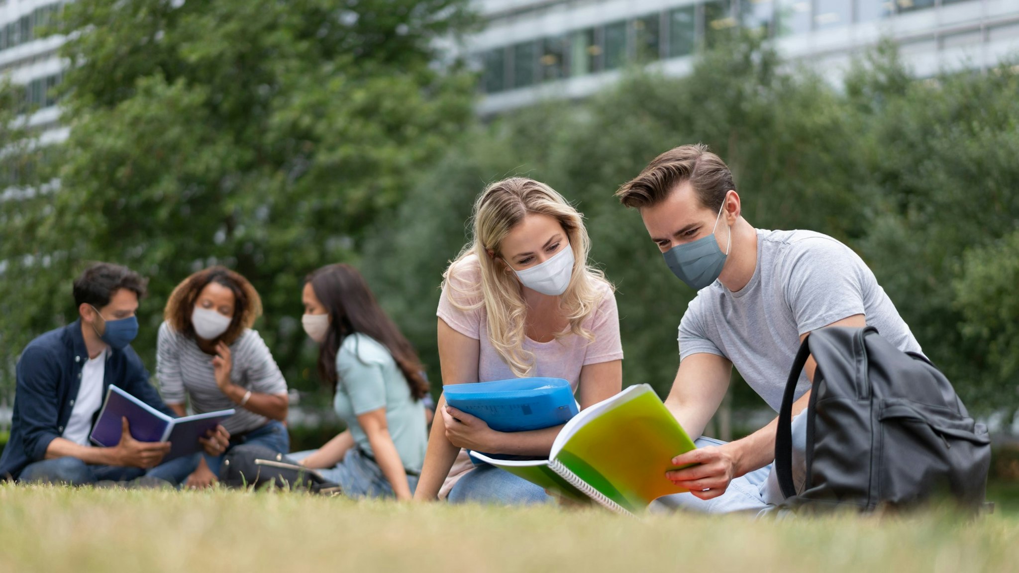 Students wearing a facemask while studying together outdoors during the COVID-19 pandemic