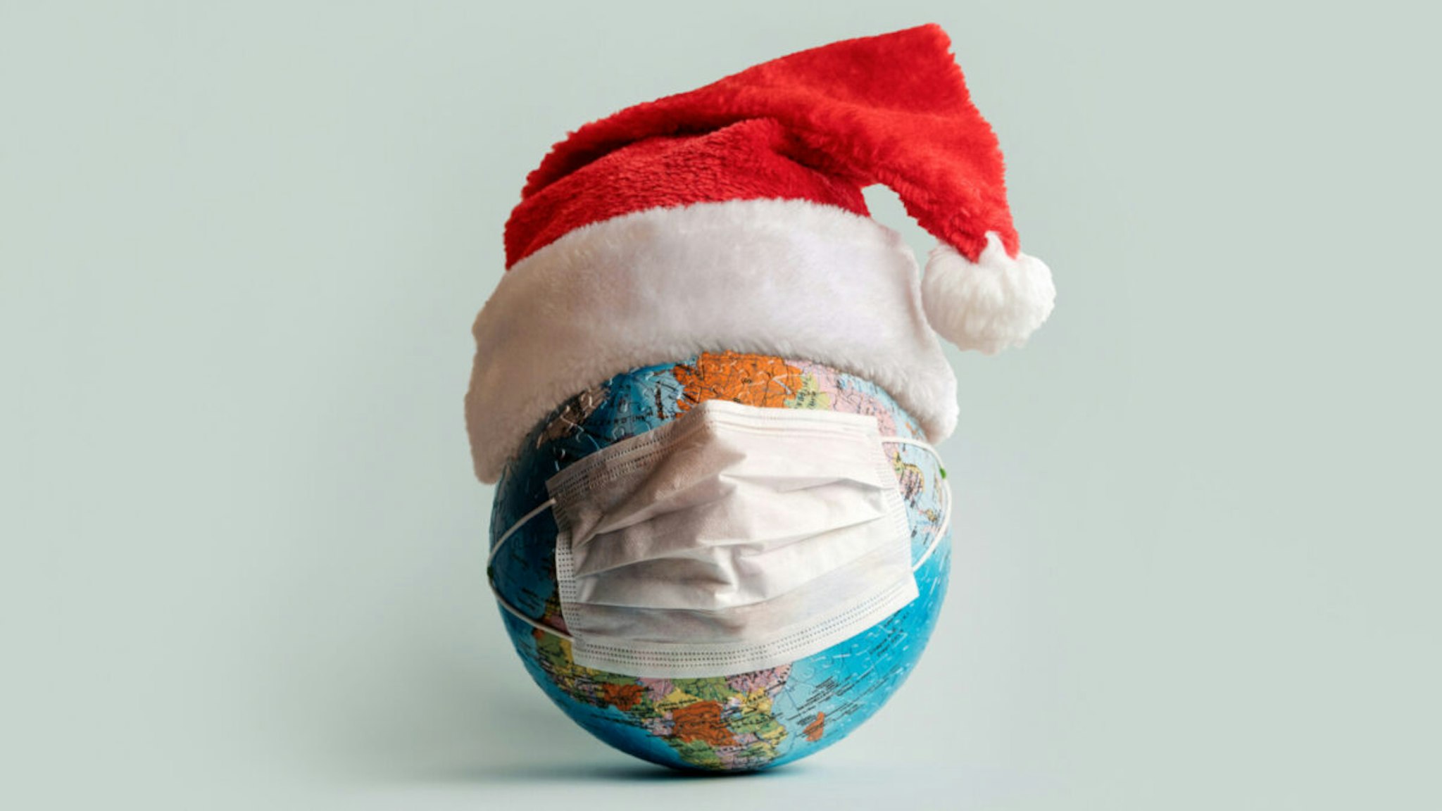 Globe made of jigsaw puzzles with a protective medical mask as a prophylaxis in the fight against coronavirus infection. Measures against the spread of the virus.