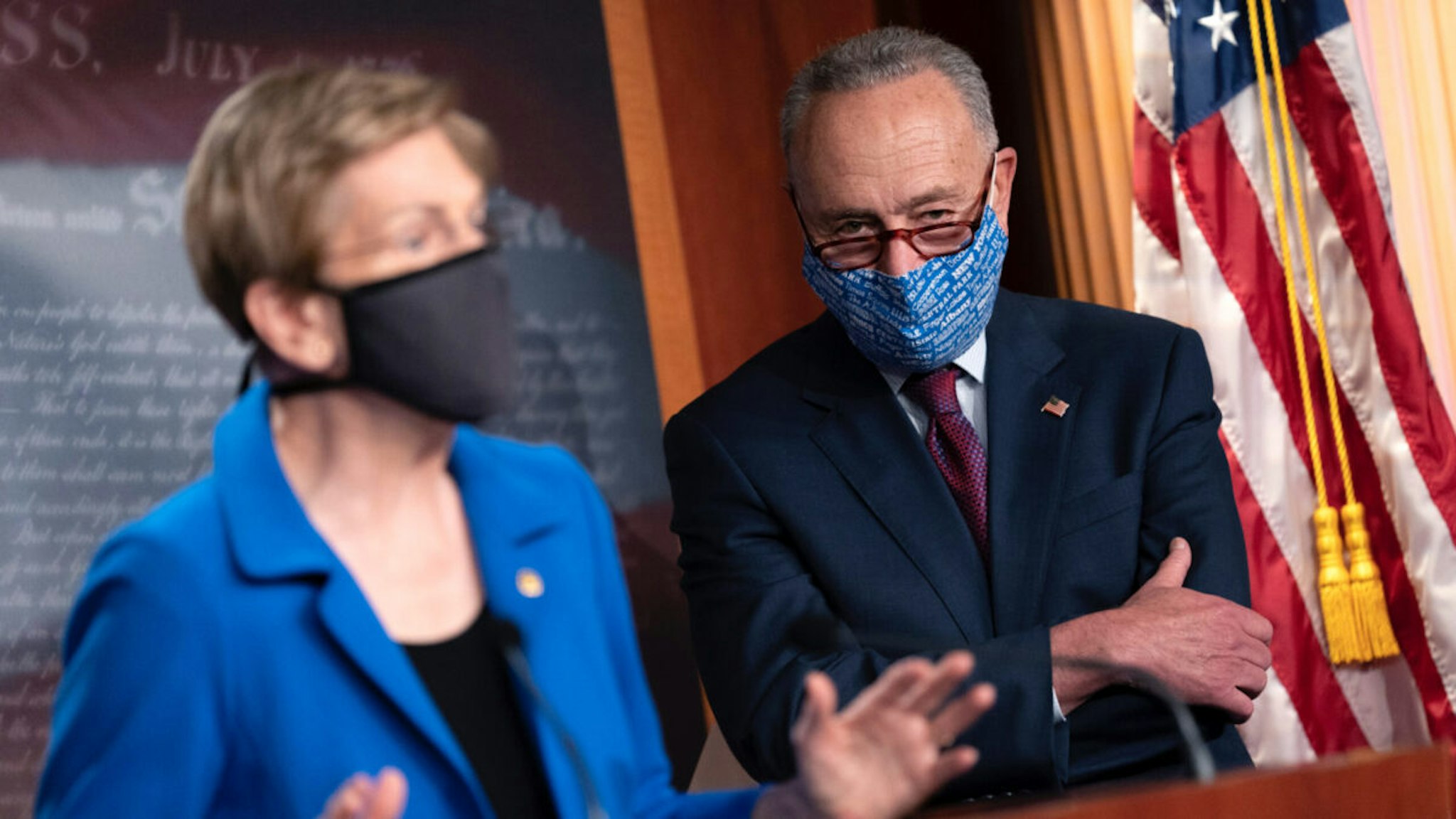 Senate Minority Leader Chuck Schumer (D-NY) (R) listens as U.S. Sen. Elizabeth Warren (D-MA) speaks during a news conference on Capitol Hill on October 20, 2020 in Washington, DC.