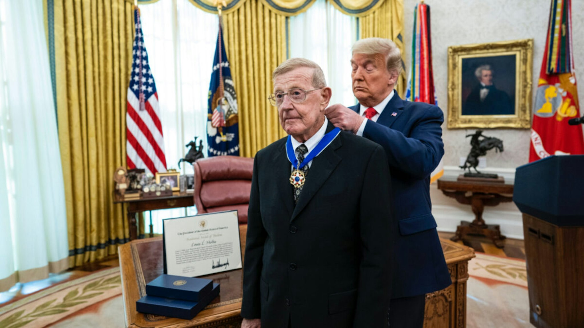 President Donald Trump presents the Medal of Freedom to former college football coach Lou Holtz in the Oval Office of the White House on December 3, 2020 in Washington, DC.