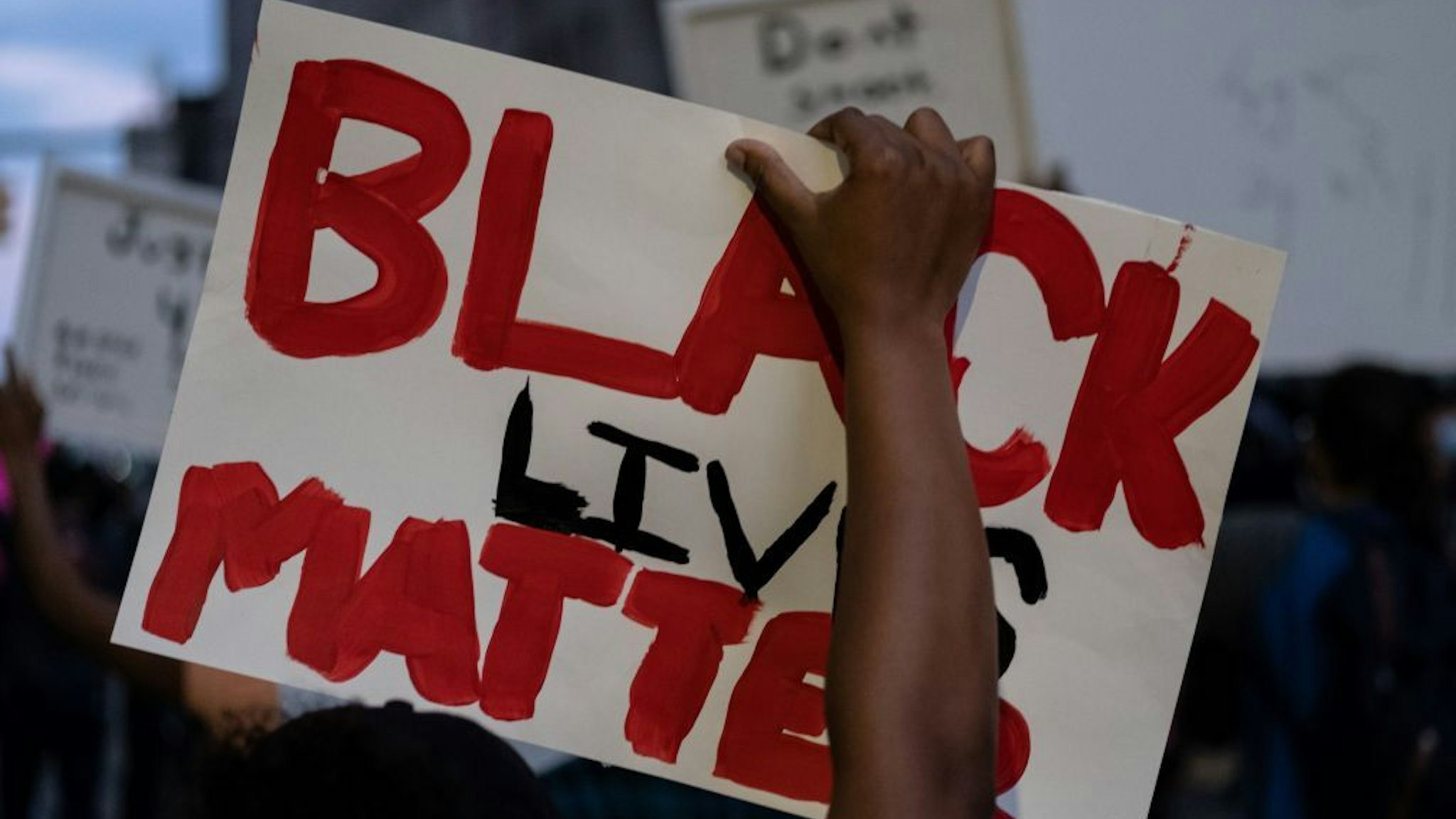 A person holds up a placard that reads, 'Black lives matter' during a protest in the city of Detroit, Michigan, on May 29, 2020, during a demonstration over the death of George Floyd, a black man who died after a white policeman knelt on his neck for several minutes. - Violent protests erupted across the United States late on May 29, over the death of a handcuffed black man in police custody, with murder charges laid against the arresting Minneapolis officer failing to quell boiling anger. (Photo by SETH HERALD / AFP) (Photo by SETH HERALD/AFP via Getty Images)