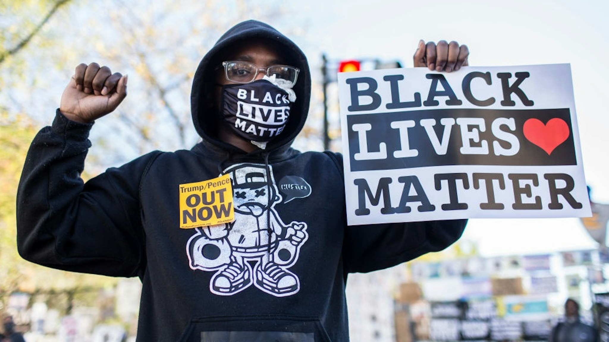 WASHINGTON, DISTRICT OF COLUMBIA, UNITED STATES - 2020/11/04: A protestor holding a sign with Black Lives Matter written on it, stands at Black Lives Matter Plaza near the White House while waiting for the final result of the 2020 Presidential election.