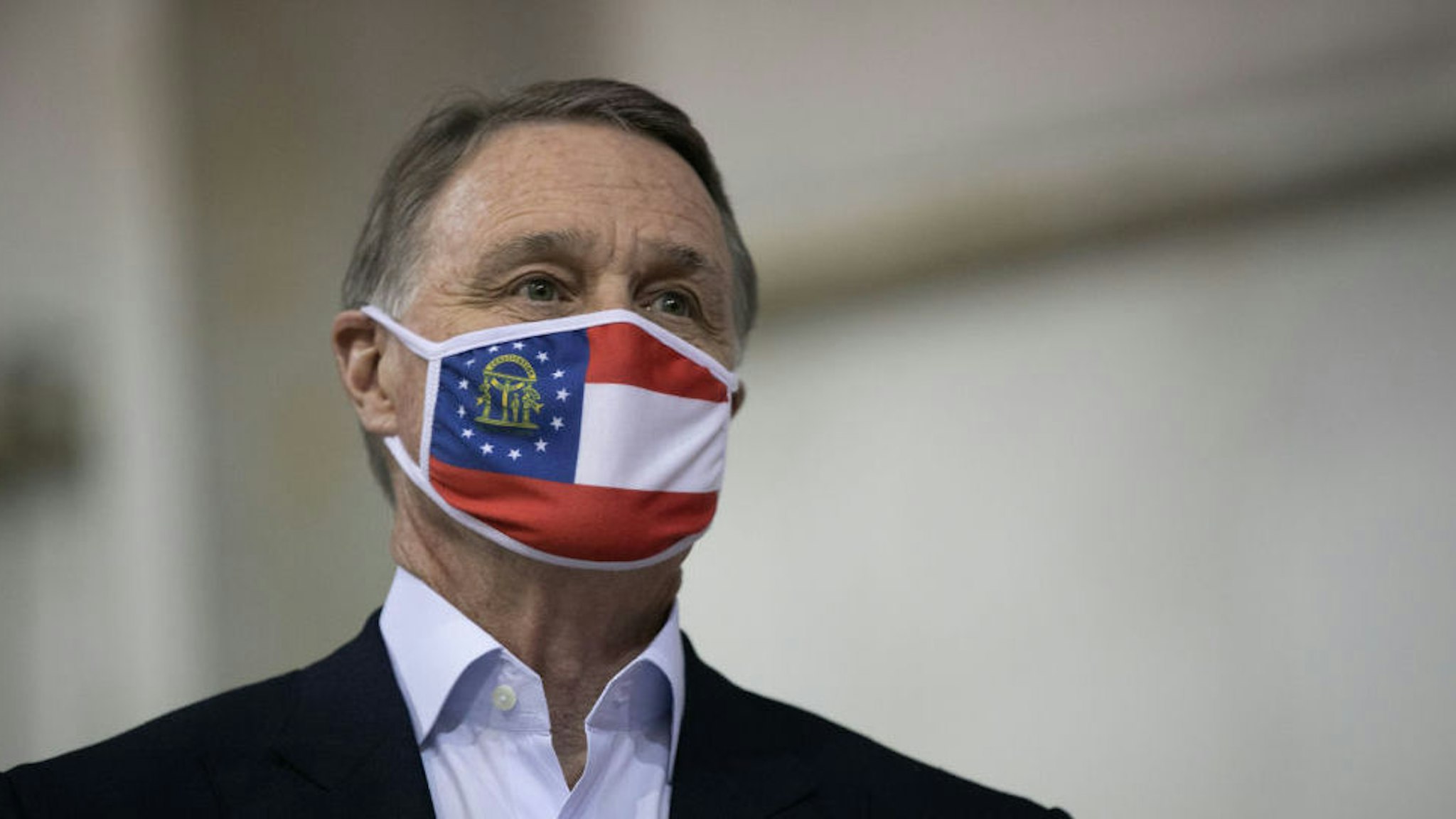 ATLANTA, GA - DECEMBER 14: Sen. David Perdue (R-GA) looks on during a campaign rally at Peachtree Dekalb Airport on December 14, 2020 in Atlanta, Georgia. As early voting begins, Perdue is facing Democratic candidate Jon Ossoff in a runoff election. The results of two Georgia Senate races will determine the party that controls the majority in the U.S. Senate.