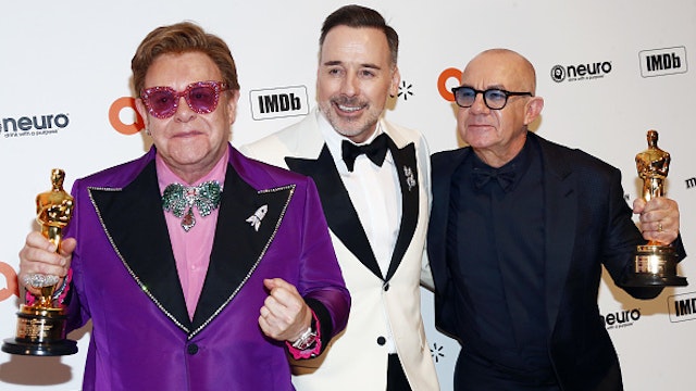 LOS ANGELES, CALIFORNIA - FEBRUARY 09: Elton John, David Furnish and Bernie Taupin walk the red carpet at the Elton John AIDS Foundation Academy Awards Viewing Party on February 09, 2020 in Los Angeles, California.