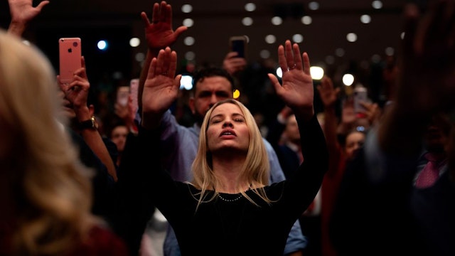 TOPSHOT - Supporters pray as US President Donald Trump speaks during a 'Evangelicals for Trump' campaign event held at the King Jesus International Ministry on January 03, 2020 in Miami, Florida. (Photo by JIM WATSON / AFP) (Photo by JIM WATSON/AFP via Getty Images)