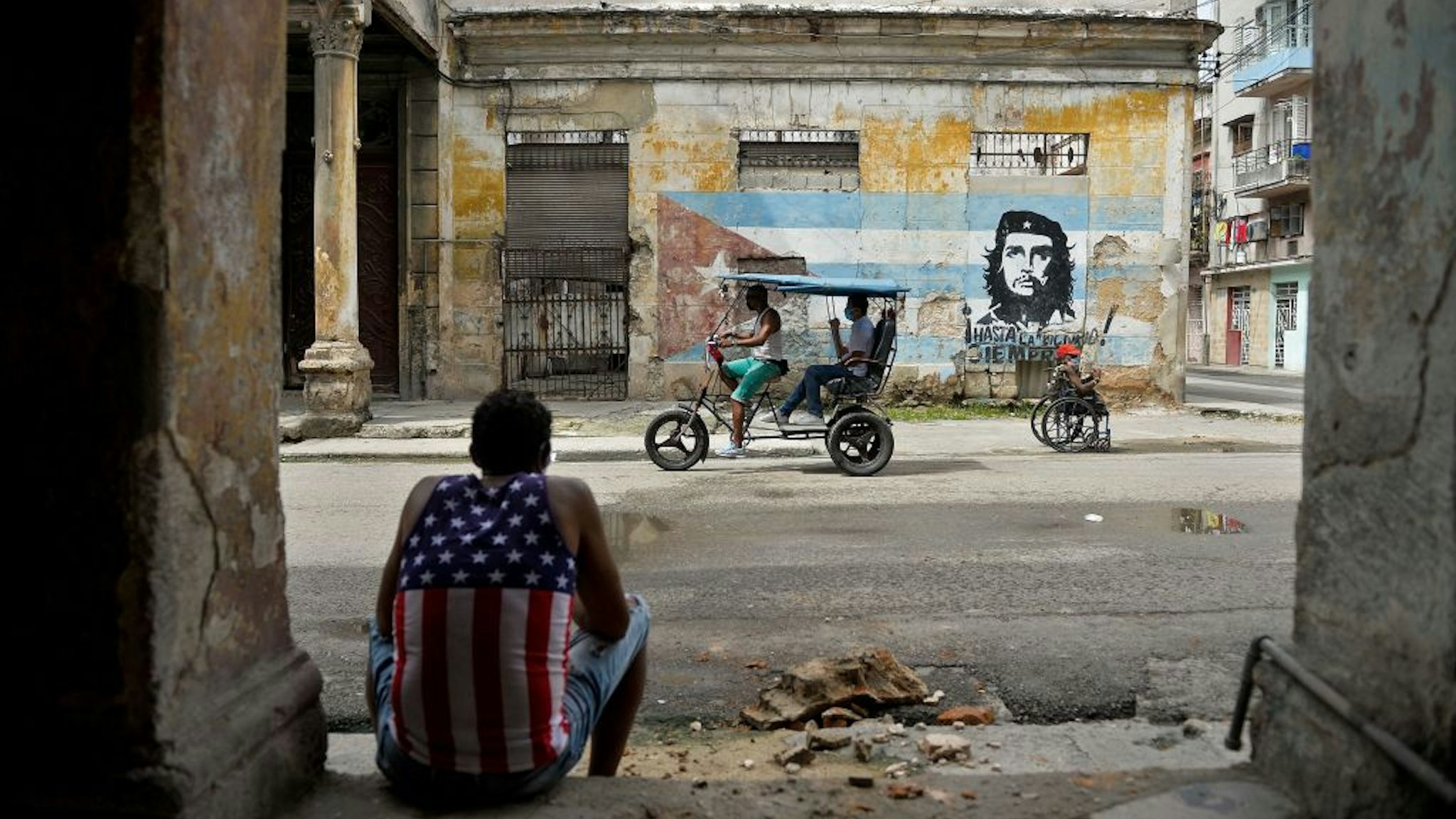 Man wearing a tank top with a design of the US flag rests in Havana on October 21, 2020, amid the COVID-19 novel coronavirus pandemic.