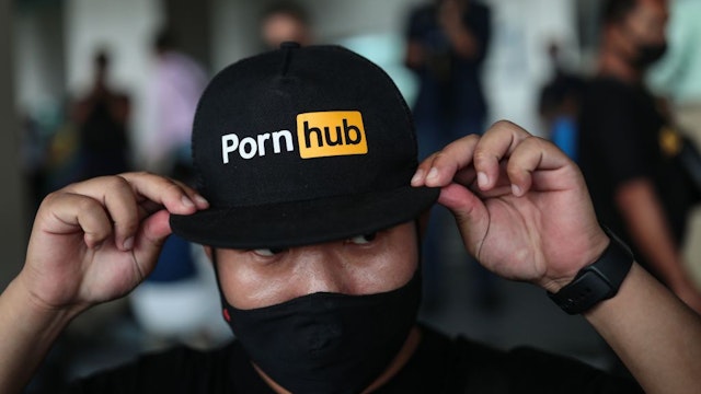 A protester wears a cap with the Pornhub logo during a demonstration at the Ministry of Digital Economy and Society in Bangkok on November 3, 2020, after the website was blocked by the ministry. (Photo by Jack TAYLOR / AFP) (Photo by JACK TAYLOR/AFP via Getty Images)