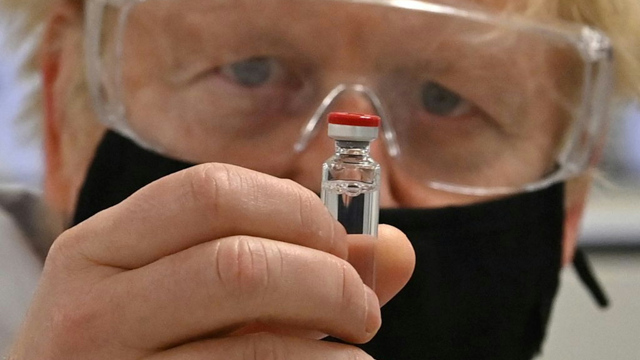 WREXHAM, WALES - NOVEMBER 30: UK Prime Minister Boris Johnson poses for a photograph with a vial of the AstraZeneca/Oxford University COVID-19 candidate vaccine, known as AZD1222, at Wockhardt's pharmaceutical manufacturing facility on November 30, 2020 in Wrexham, Wales. The UK government announced a deal in August with global pharmaceutical and biotechnology company Wockhardt, to increase capacity in a crucial part of the manufacturing process for Covid-19 vaccines. Britain has been Europe's worst-hit country during the pandemic, recording more than 57,000 deaths from some 1.6 million cases. (Photo by Paul Ellis - WPA Pool/Getty Images)