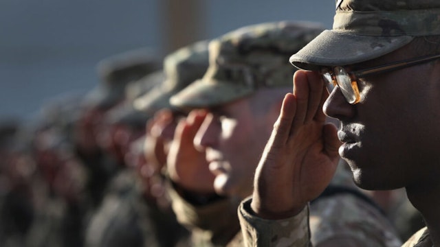 BAGRAM, AFGHANISTAN - SEPTEMBER 11: U.S. Army soldiers salute during the national anthem during the an anniversary ceremony of the terrorist attacks on September 11, 2001 on September 11, 2011 at Bagram Air Field, Afghanistan. Ten years after the 9/11 attacks in the United States and after almost a decade war in Afghanistan, American soldiers paid their respects in a solemn observence of the tragic day.