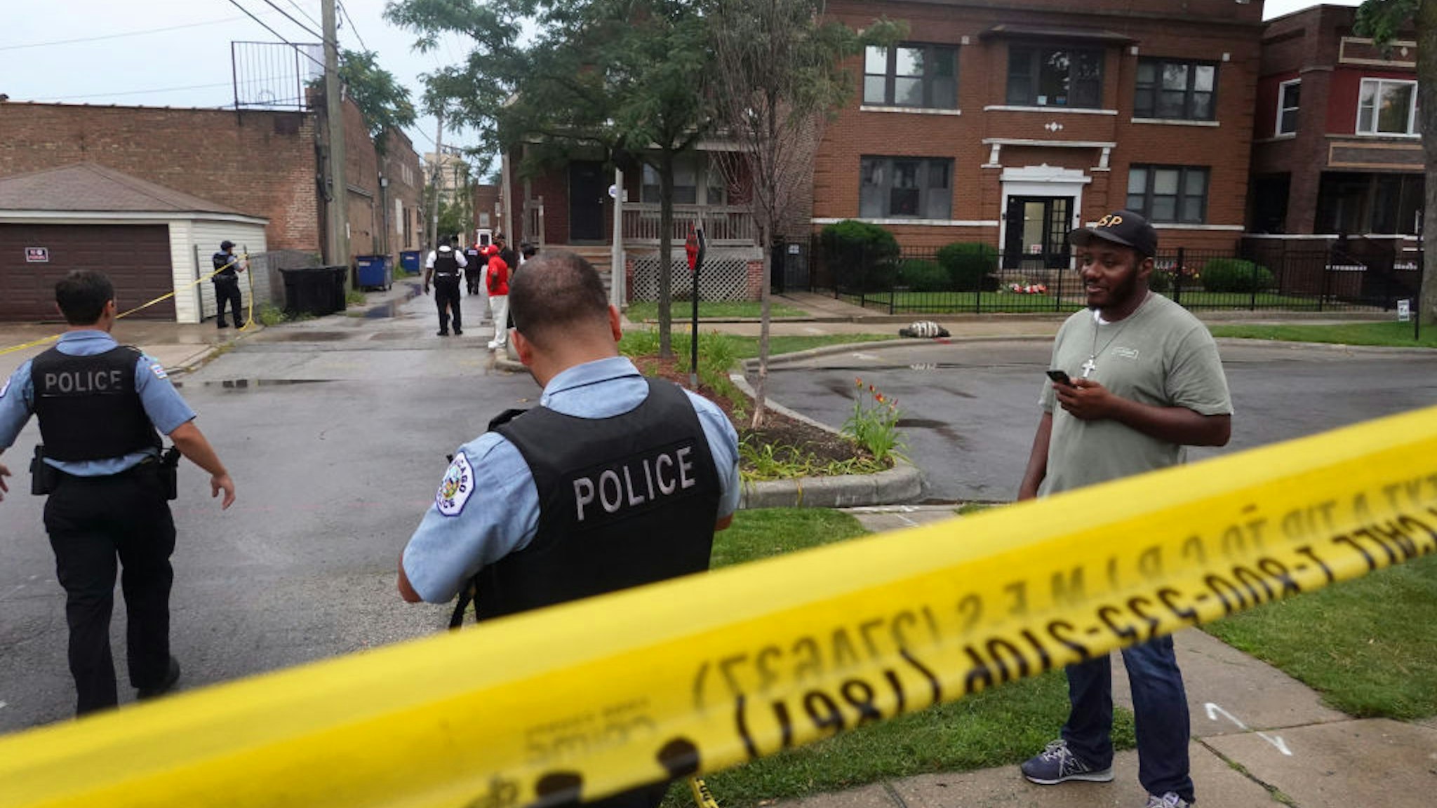 CHICAGO, ILLINOIS - JULY 21: Police secure the scene of a shooting in the Auburn Gresham neighborhood on July 21, 2020 in Chicago, Illinois. At least 14 people were transported to area hospitals after several gunmen opened fire on mourners standing outside of a funeral home. More than 2000 people have been shot and more than 400 have been murdered in Chicago so far this year. (Photo by Scott Olson/Getty Images)