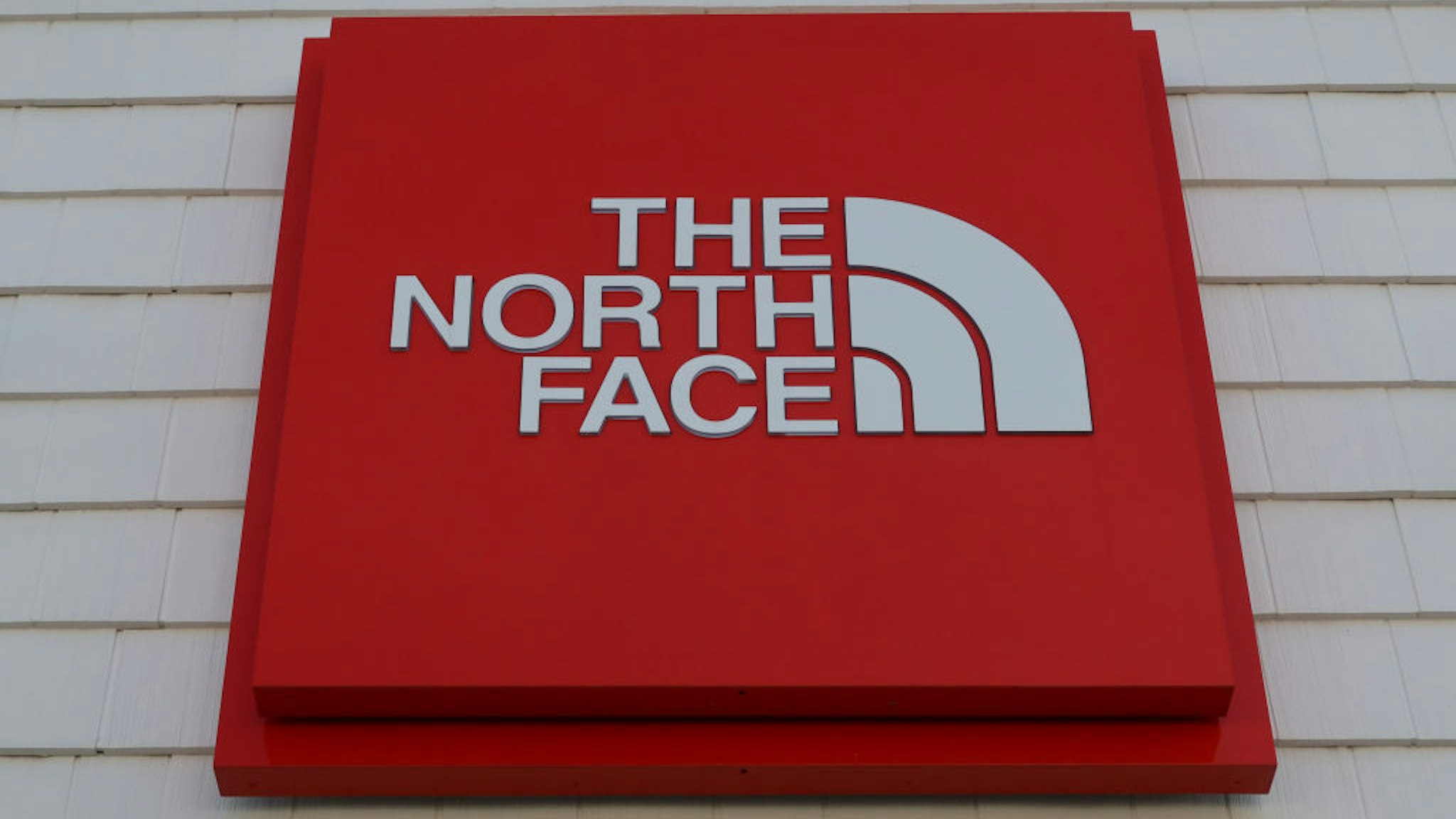 A The North Face sign hangs in front of their store at the Woodbury Common Premium Outlets shopping mall on November 24, 2020 in Central Valley, New York.