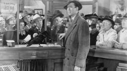A Wonderful Job 1946: American actor James Stewart (1908 - 1997) stands in the cashier's cubicle of a bank next to a black crow, while a crowd of people wait in the background, in a still from director Frank Capra's film, 'It's a Wonderful Life'. (Photo by Hulton Archive/Getty Images)