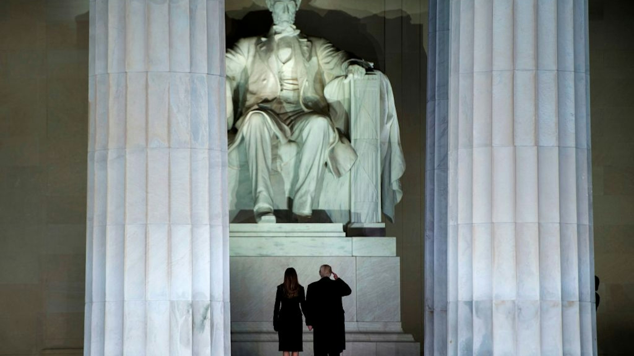 TOPSHOT - US President-elect Donald Trump and wife Melania look at the Abraham Lincoln statue as they arrive for a welcome celebration at the Lincoln Memorial in Washington, DC, on January 19, 2017. (Photo by Brendan Smialowski / AFP) (Photo by BRENDAN SMIALOWSKI/AFP via Getty Images)