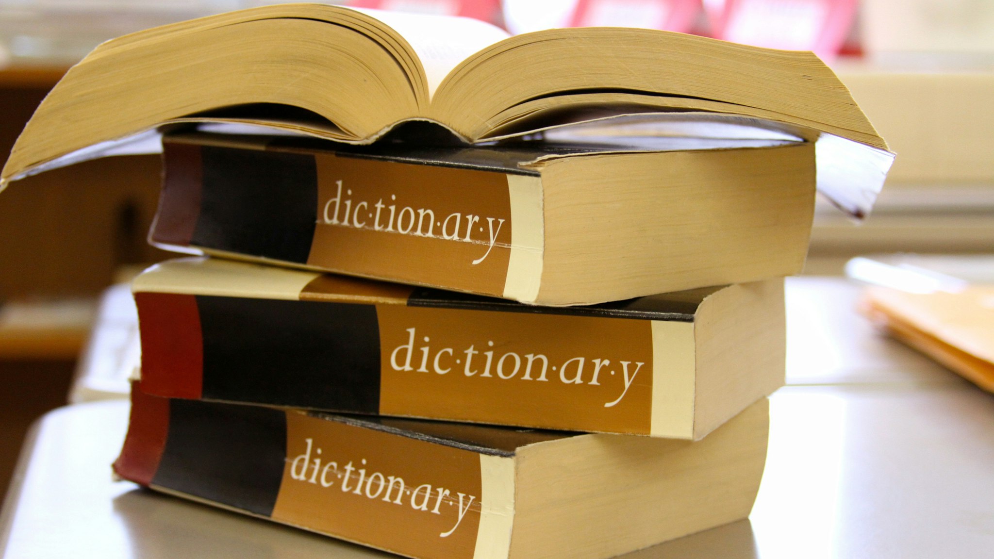 Stack of dictionaries on a desk - stock photo