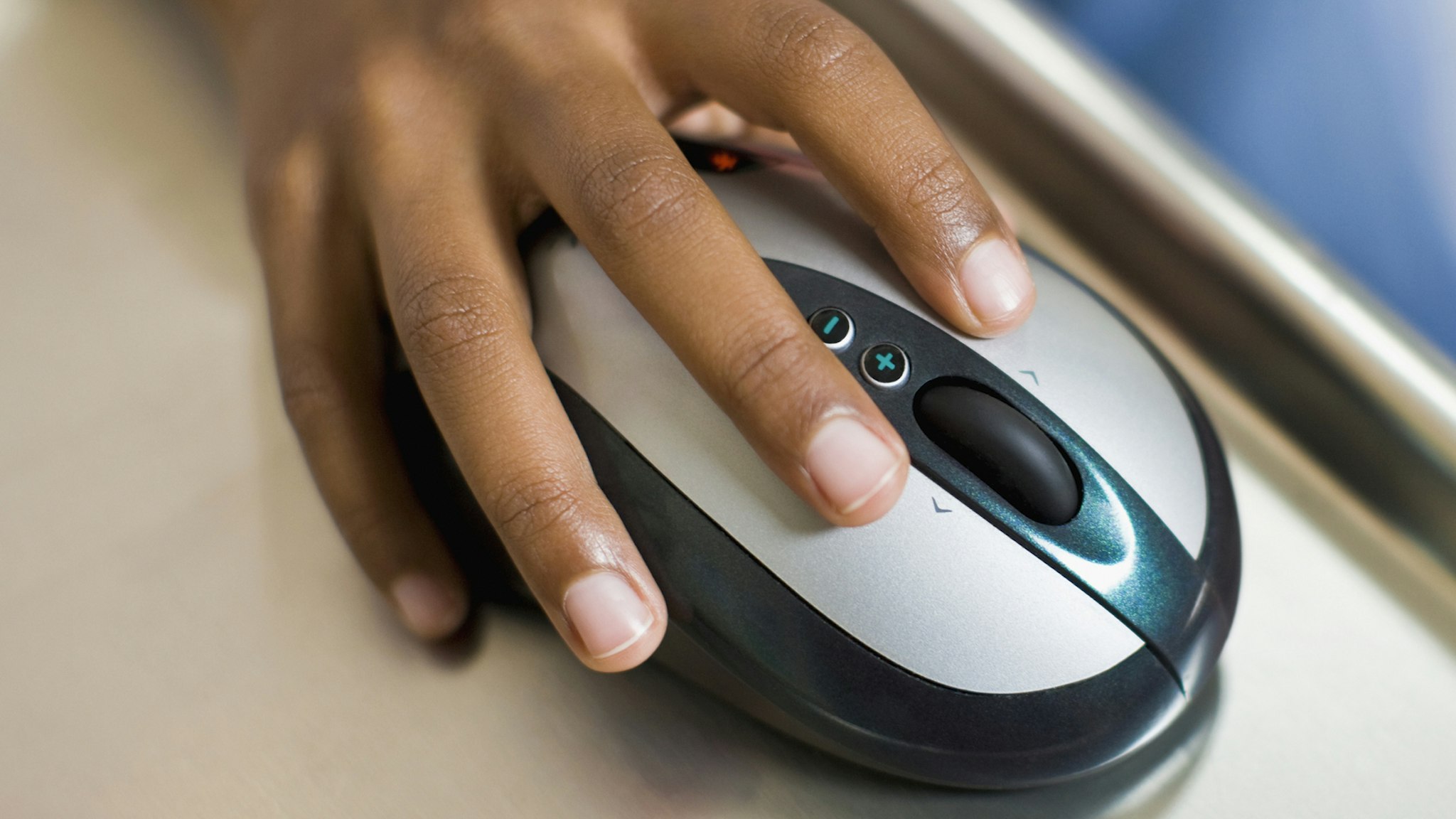 African girl's hand on computer mouse - stock photo