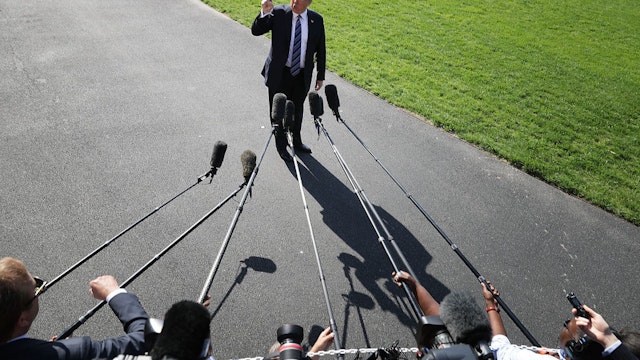 WASHINGTON, DC - MAY 25: U.S. President Donald Trump points up to the second floor of the White House and tells members of the news media that first lady Melania Trump is watching him depart the White House May 25, 2018 in Washington, DC. Trump is traveling to Annapolis, Maryland, to participate in the Naval Academy's graduation ceremony. (Photo by Chip Somodevilla/Getty Images)
