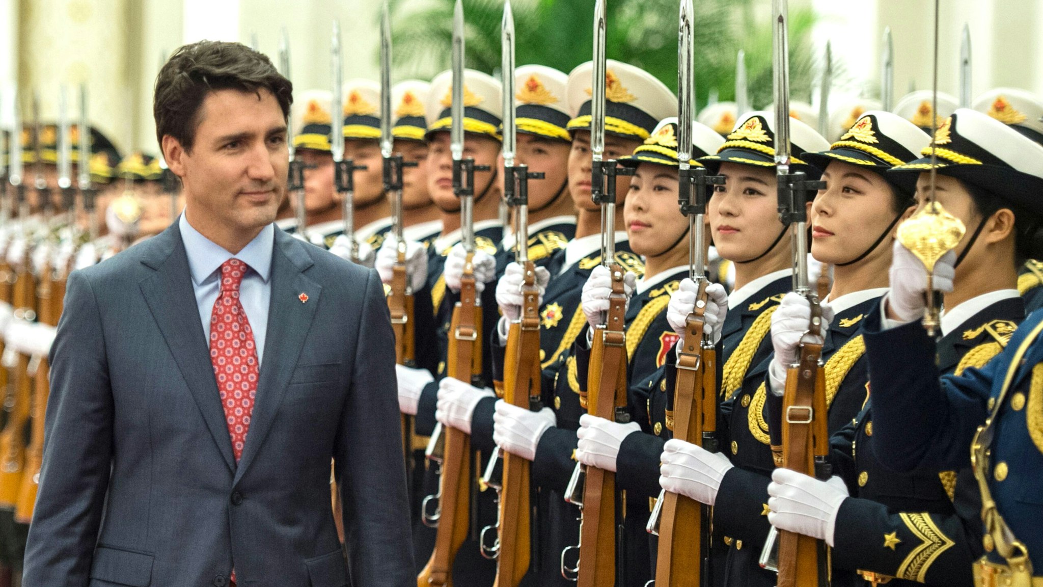Canada's Prime Minister Justin Trudeau walks during a review of Chinese paramilitary guards with China's Premier Li Keqiang during a welcome ceremony at the Great Hall of the People in Beijing on December 4, 2017.
