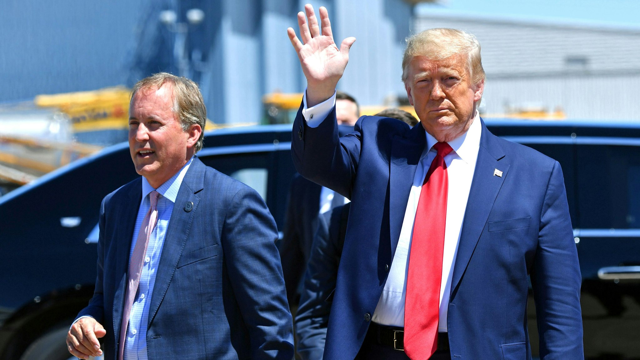 US President Donald Trump waves upon arrival, alongside Attorney General of Texas Ken Paxton (L) in Dallas, Texas, on June 11, 2020, where he will host a roundtable with faith leaders and small business owners.
