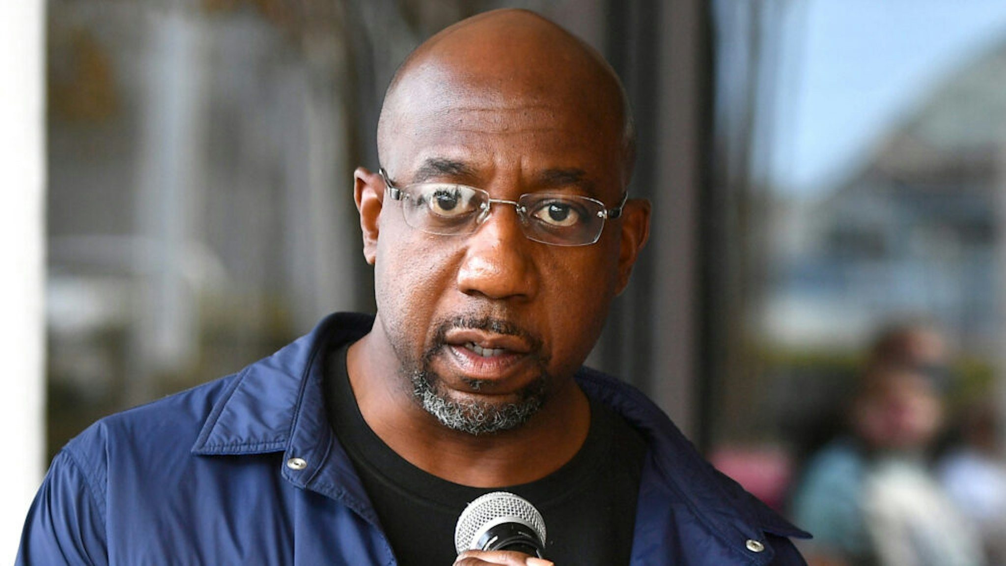 ATLANTA, GEORGIA - NOVEMBER 26: Raphael Warnock speaks onstage during Hosea Helps Thanksgiving Dinner Drive Thru at Georgia World Congress Center on November 26, 2020 in Atlanta, Georgia. The annual event was converted into an drive thru outdoor concept due to ongoing COVID-19 pandemic.