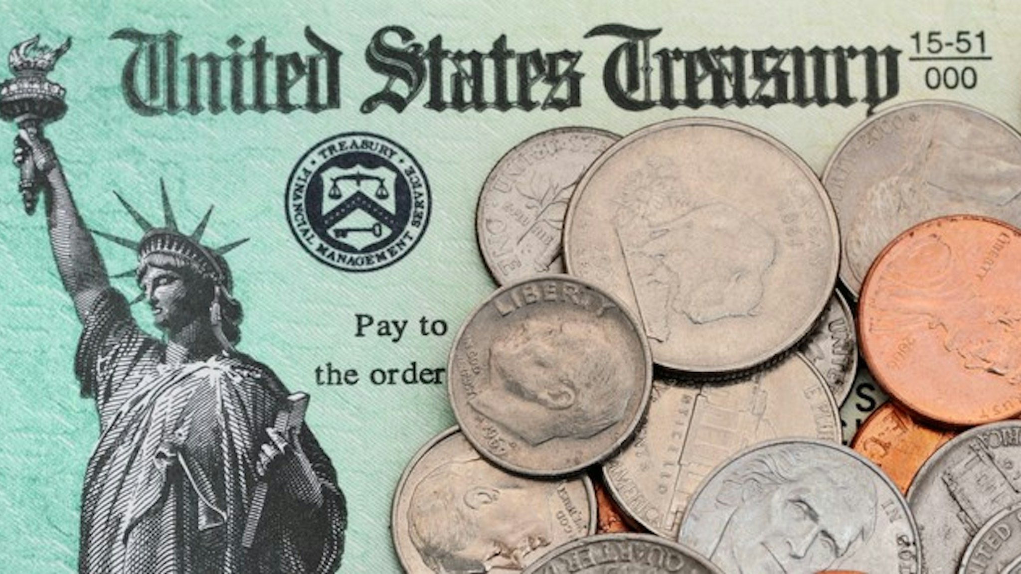 US coins are scattered across an IRS tax refund check